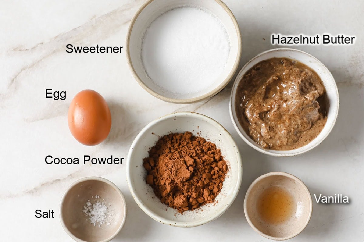 Ingredients to make keto nutella cookies, measured into bowls and labelled.