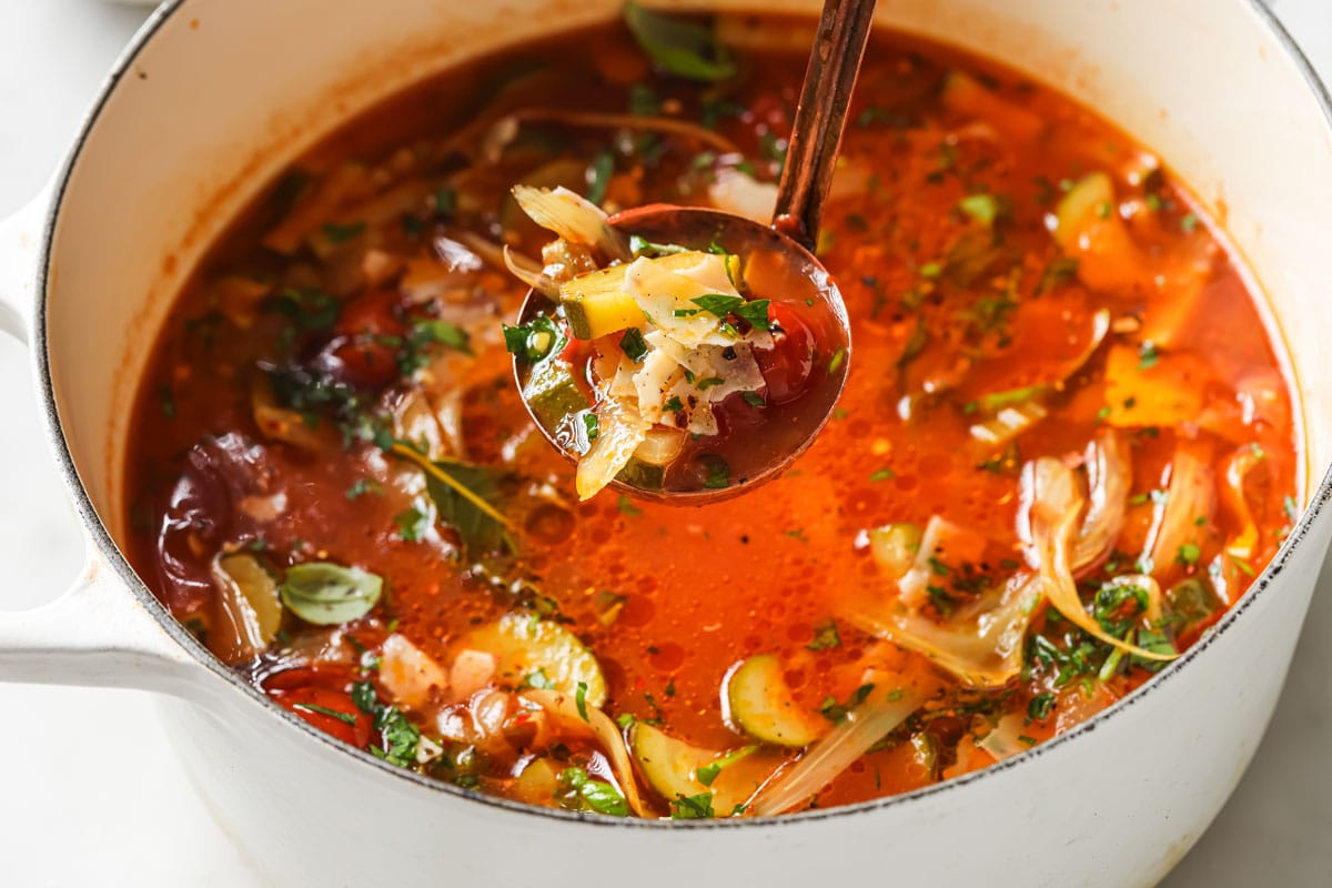 Ladle lifting soup from a soup pot.