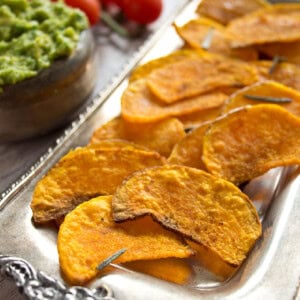 Crispy Butternut squash chips on a silver tray.