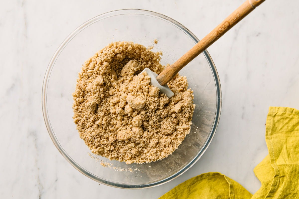 A bowl with nut flours and other dry ingredients for gingerbread cookies and a spatula.
