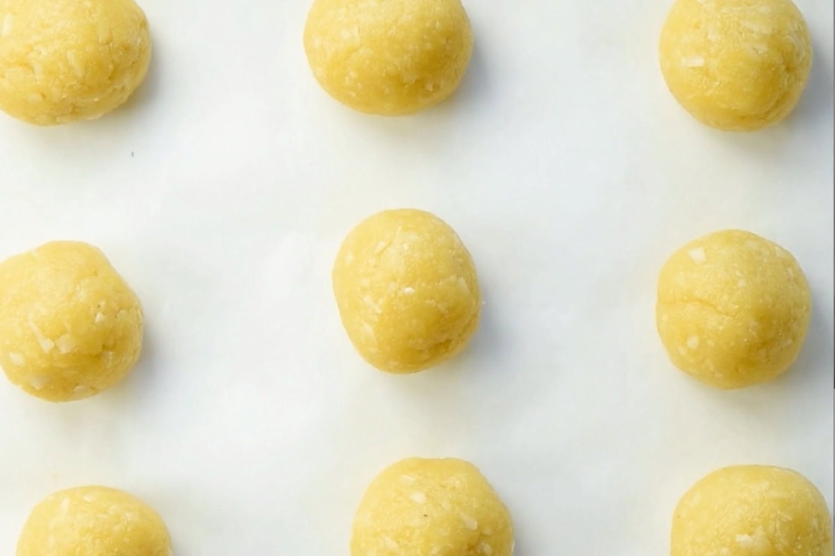 Cookie dough balls on parchment paper.