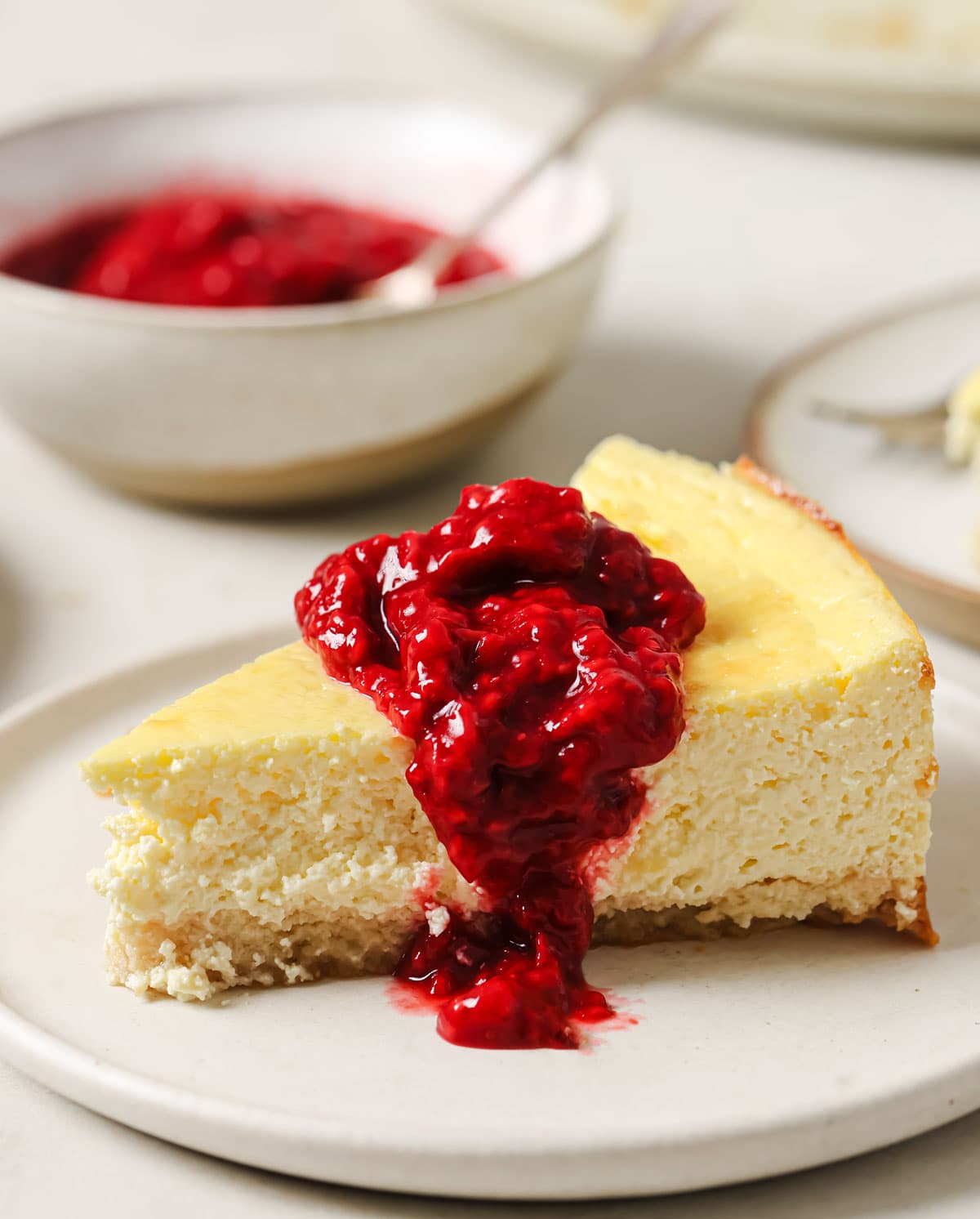 A slice of cheesecake topped with raspberry coulis.