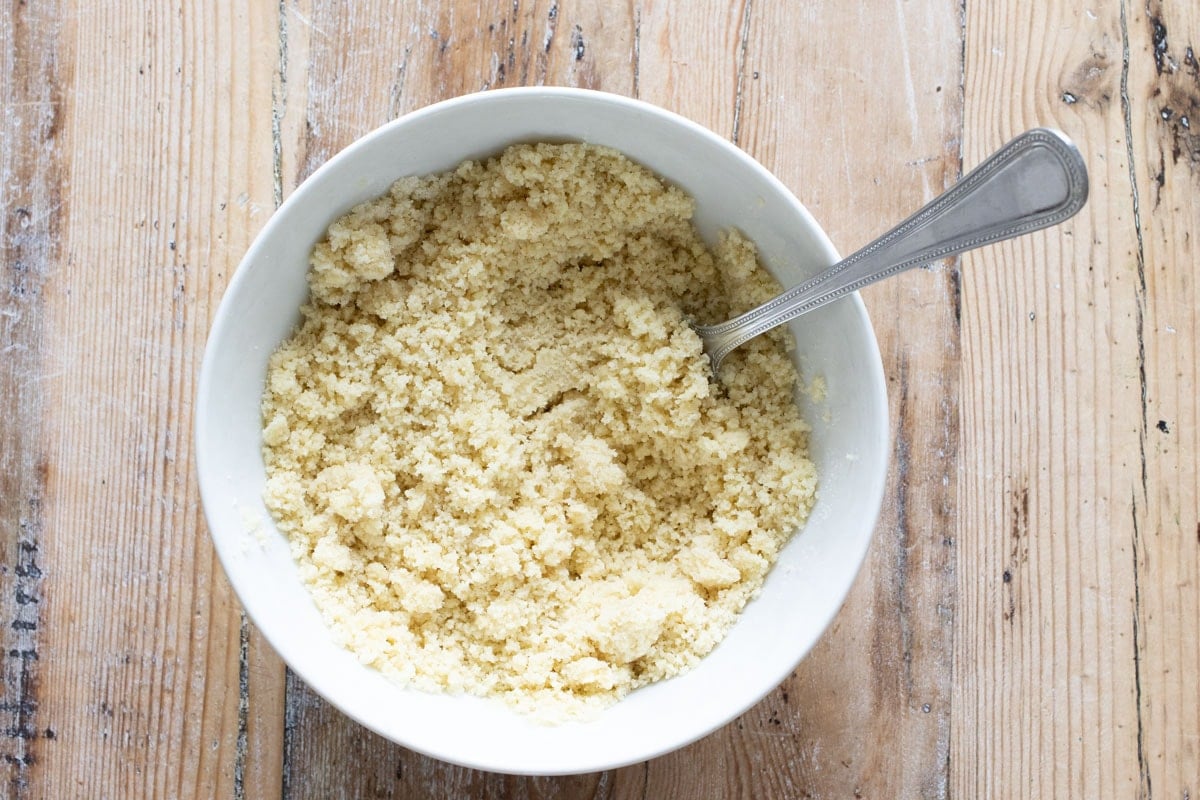 The mixed crust ingredients - Almond flour with olive oil, sweetener and vanilla - in a bowl.