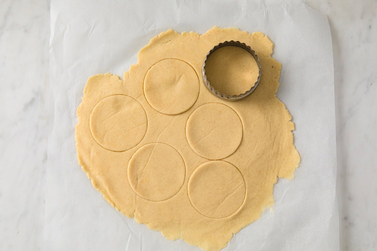 Cutting out circles from rolled out pastry.