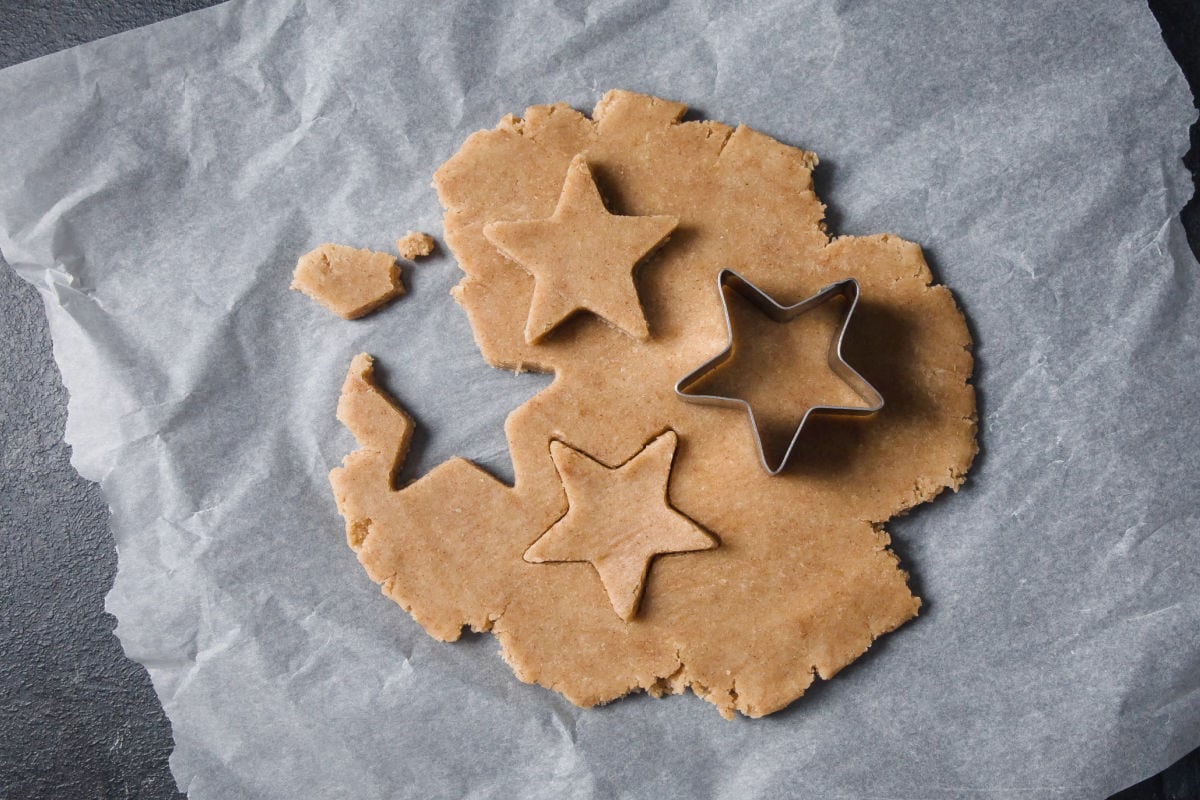 Rolled out dough and a star shaped cookie cutter.