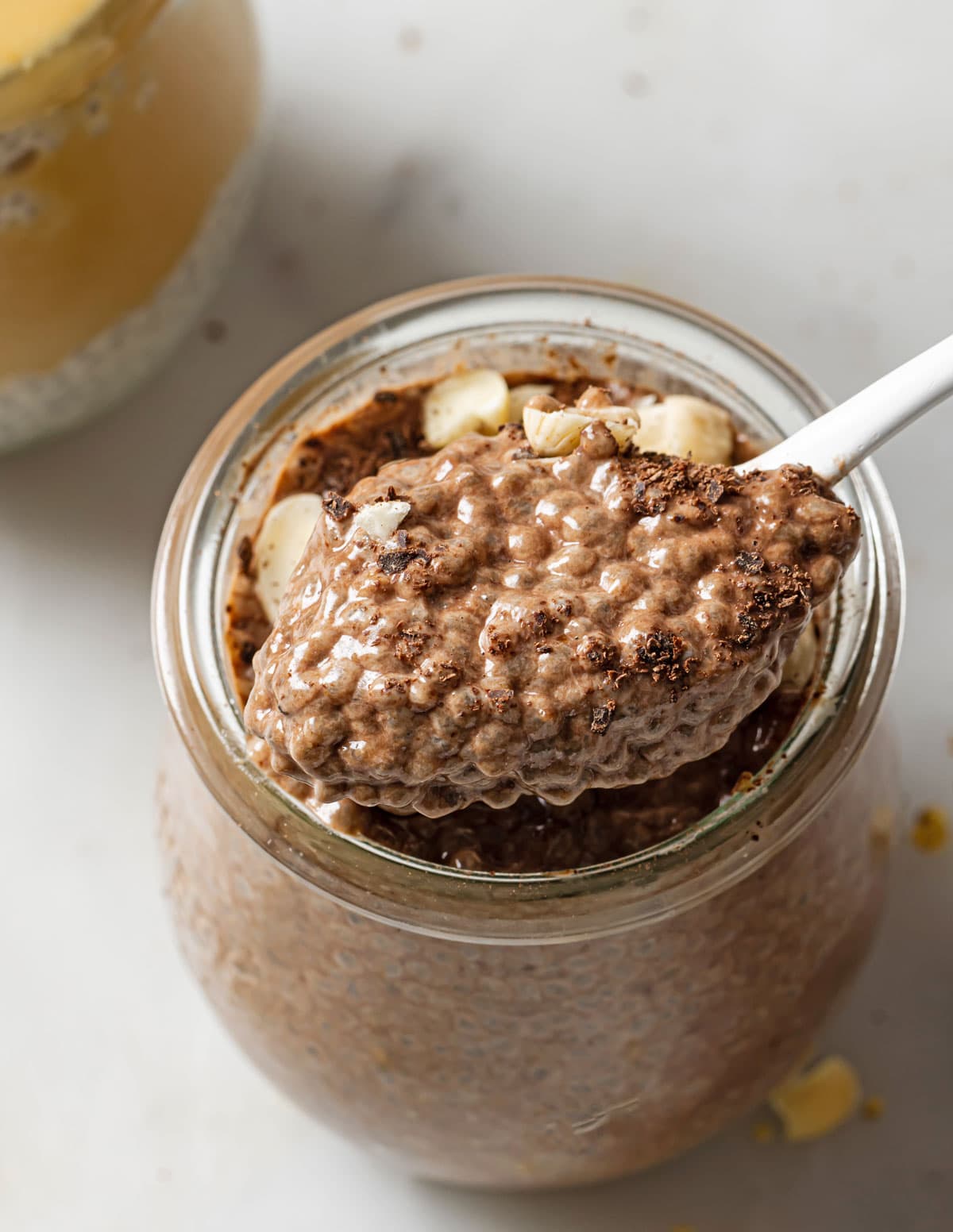 A chocolate flavored protein chia pudding and a spoon.