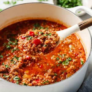 A ladle with unstuffed pepper soup that's keto friendly.