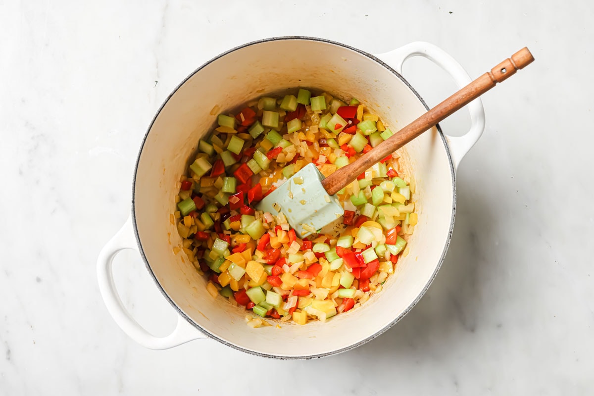 Frying chopped peppers, celery and onions in a pot.