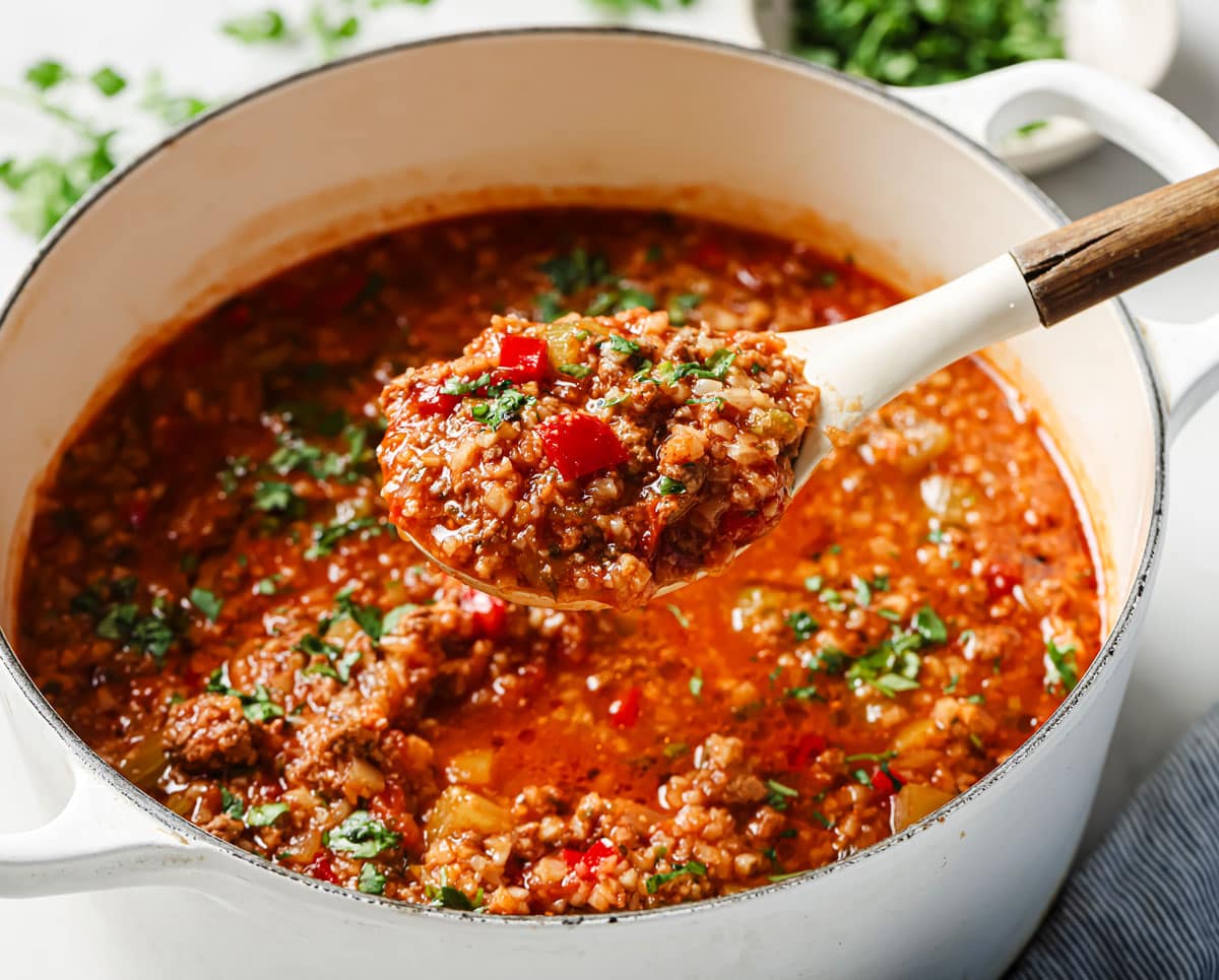 Taking a spoonful of unstuffed pepper soup from the pot.