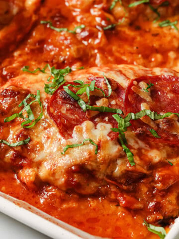 A pizza chicken fillet in a casserole dish - chicken breast topped with tomato sauce, cheese and salami.