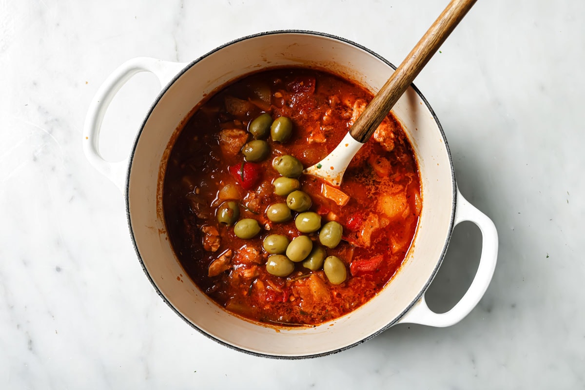 Adding olives to the stew.