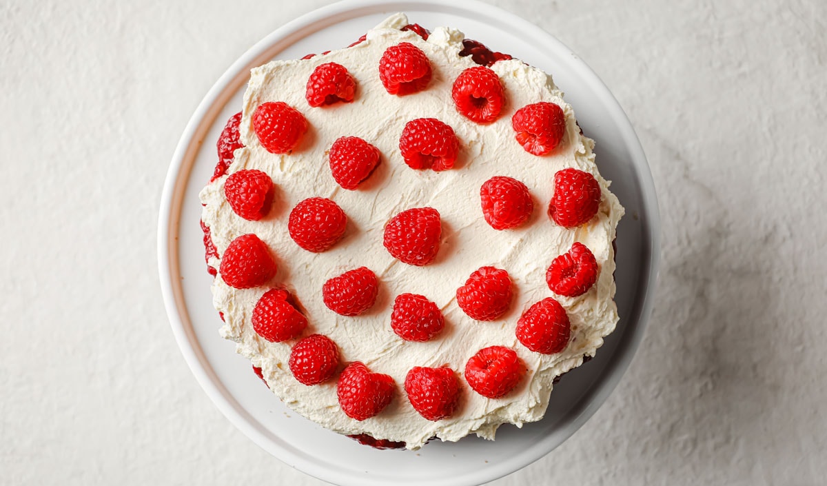 Adding raspberries onto the whipped cream layer.