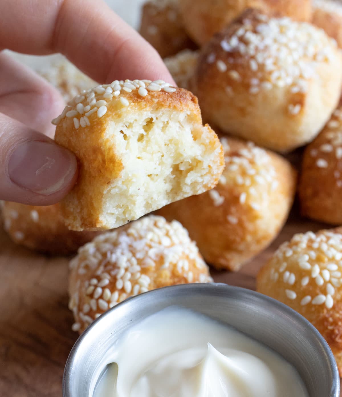 A bitten into keto pretzel bite topped with sesame seeds and sea salt.