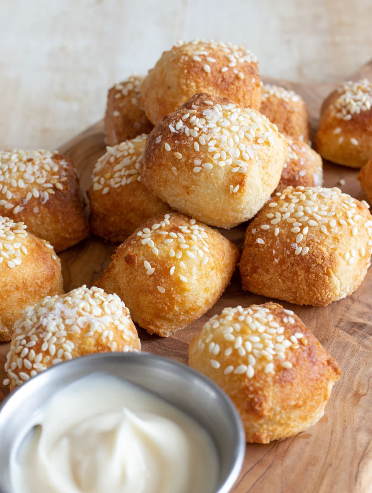 Keto pretzel bites on a wooden board with a bowl of mayo.