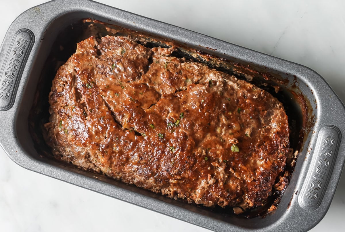 Baked and browned keto meatloaf no sauce in a loaf pan.