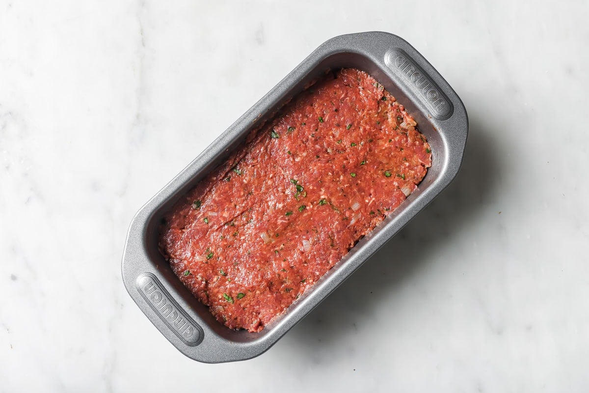 The meatloaf mixture spread in a baking pan.