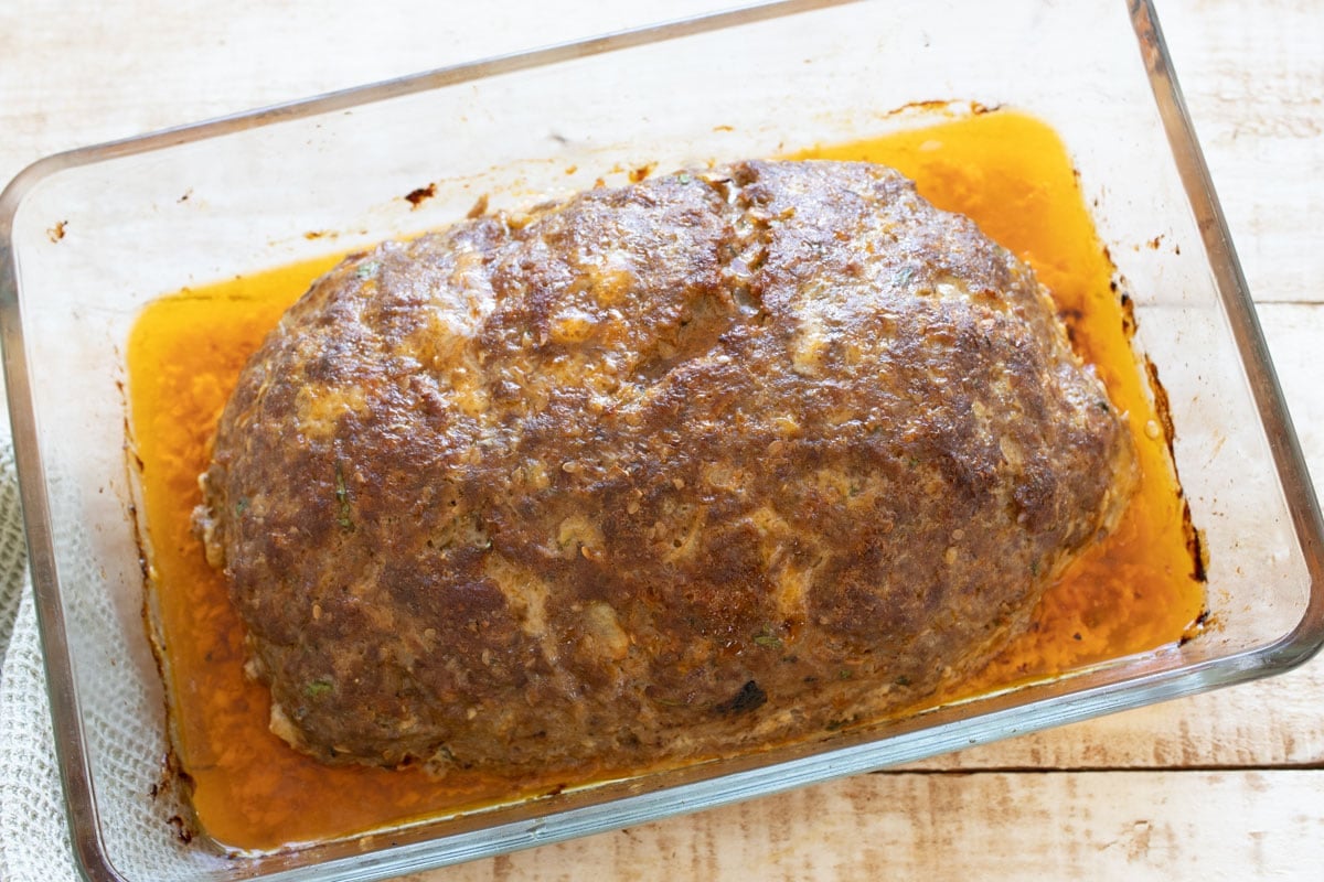 Baked browned meatloaf before glazing in a casserole.