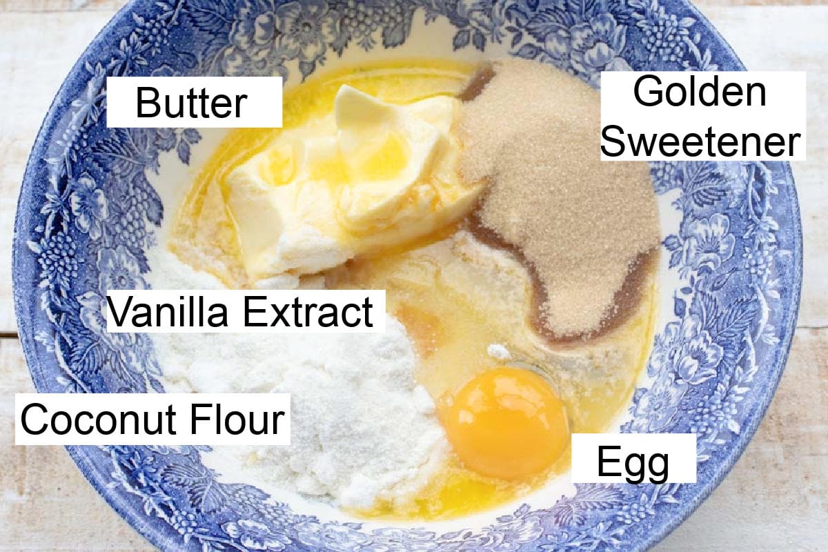Ingredients to make coconut flour cookies, measured into a mixing bowl and labelled.