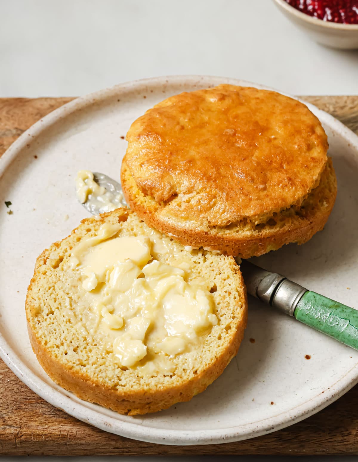The single serve flaxseed bread sliced in half and buttered on a plate.