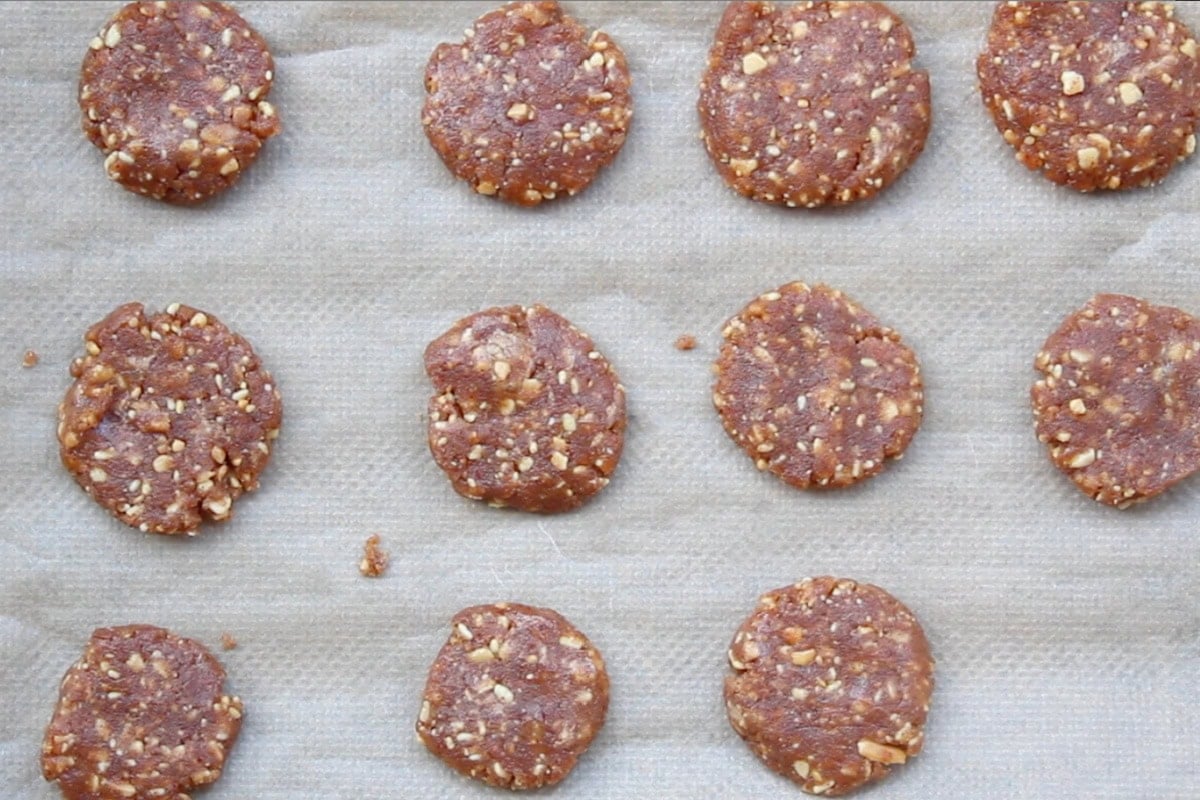 Flattened peanut butter cookies on a baking before baking.