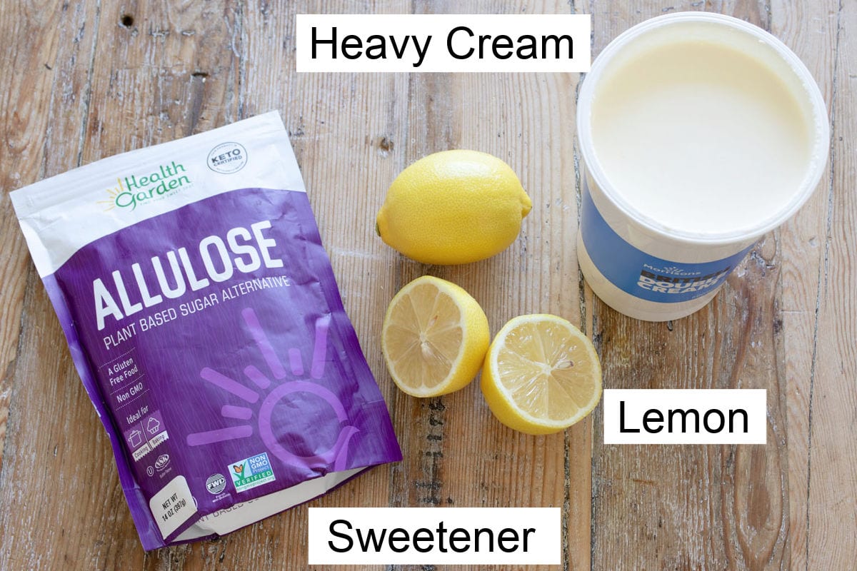 A bag of allulose, 2 lemons and a pot of cream on a table, labelled.