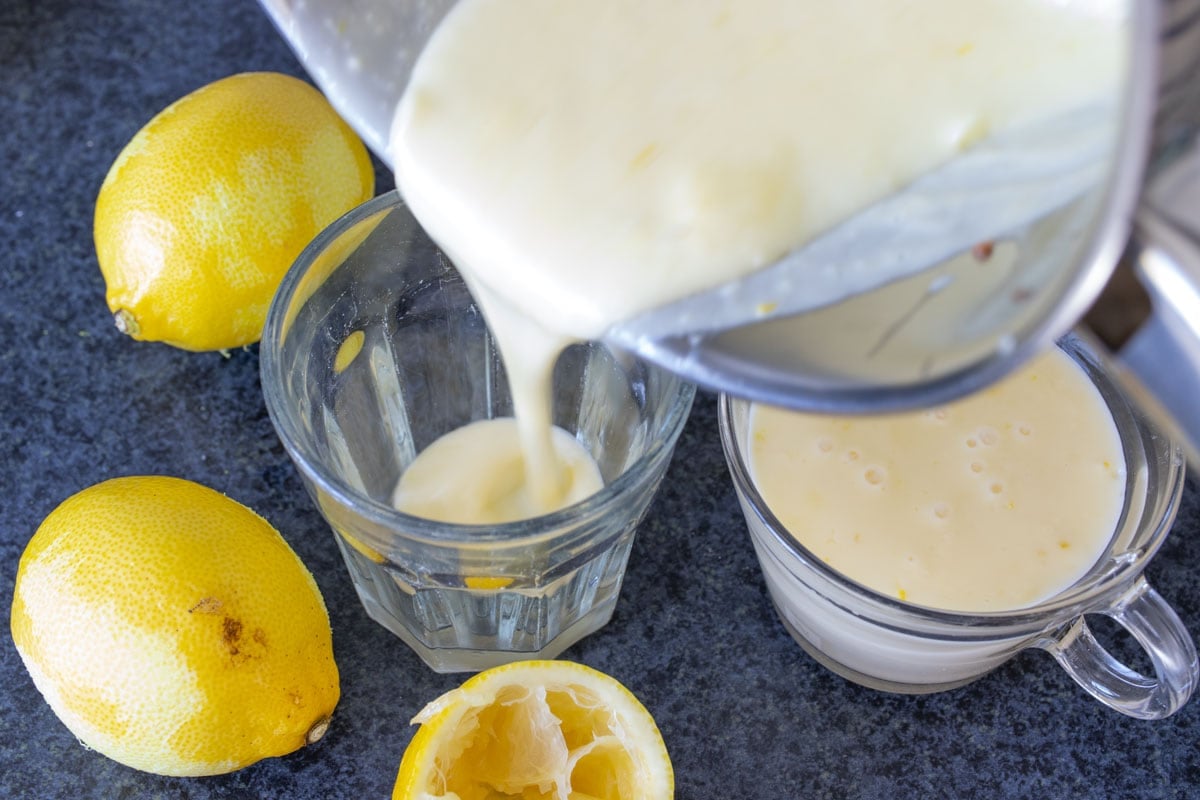 Pouring the lemon posset mixture into dessert cups.