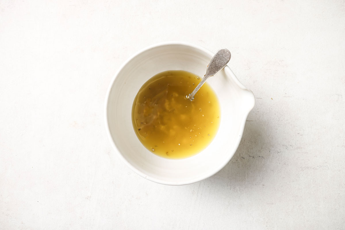 Mixing the dressing in a bowl.