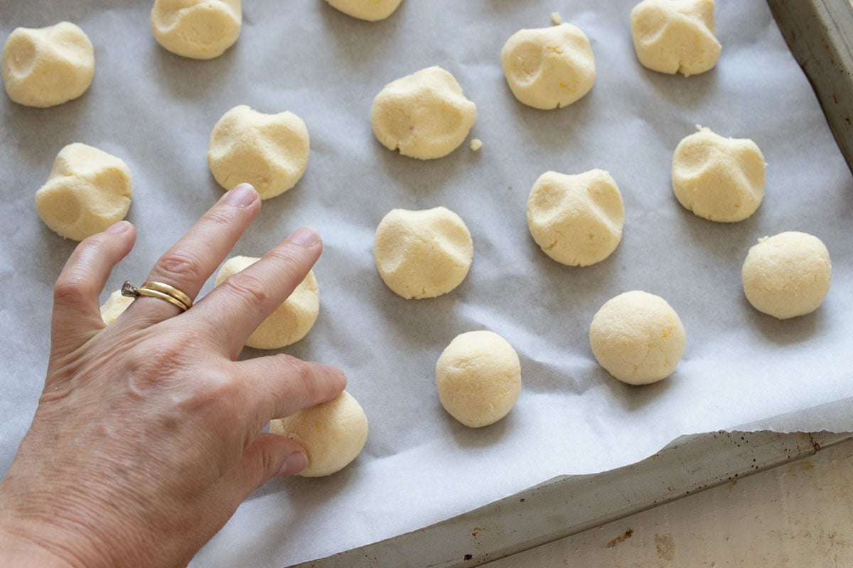 Pressing the cookie dough into shape with a hand.