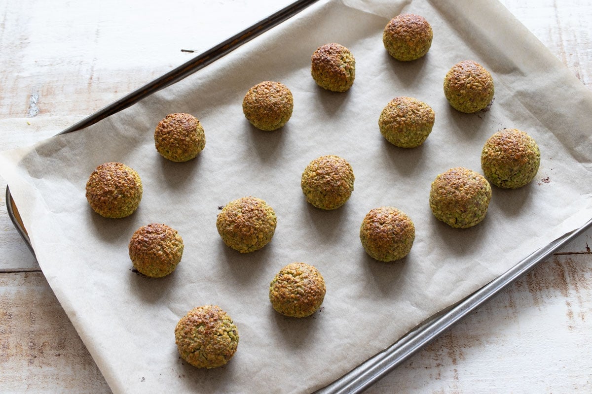 Baked sugar free pistachio cookies on a cookie sheet lined with parchment paper.