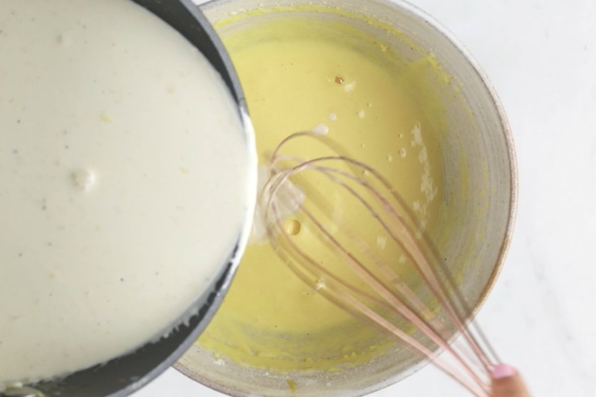 Combining the cream and whipped egg yolks with a spatula.
