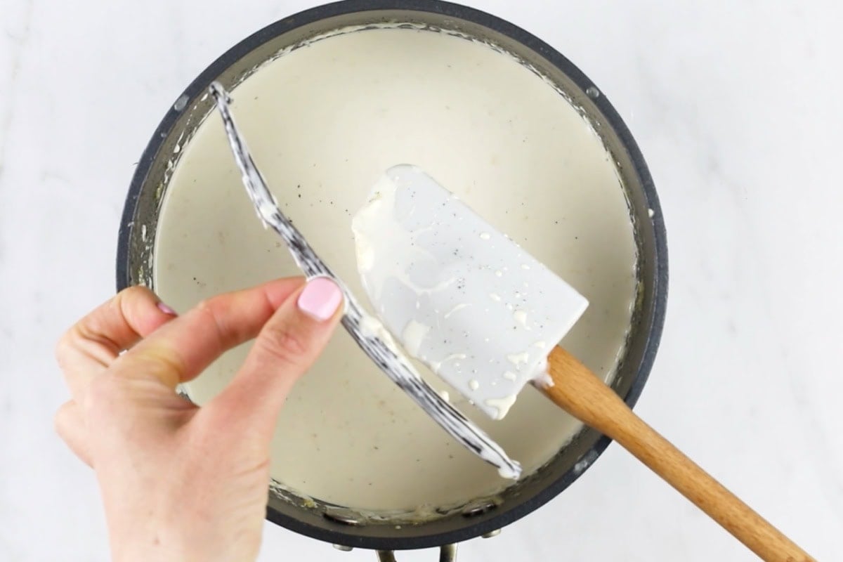 Removing the vanilla pod from the cream mixture.