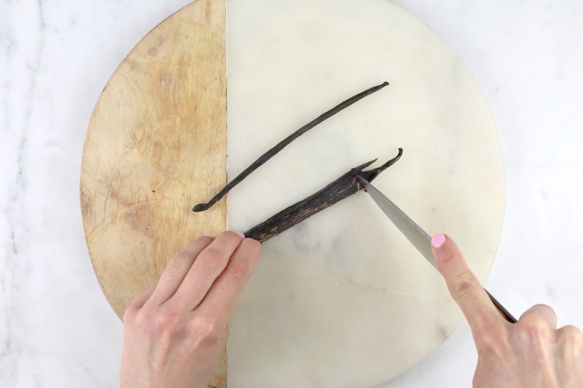 Scraping the vanilla seeds out of a vanilla pod with a knife.