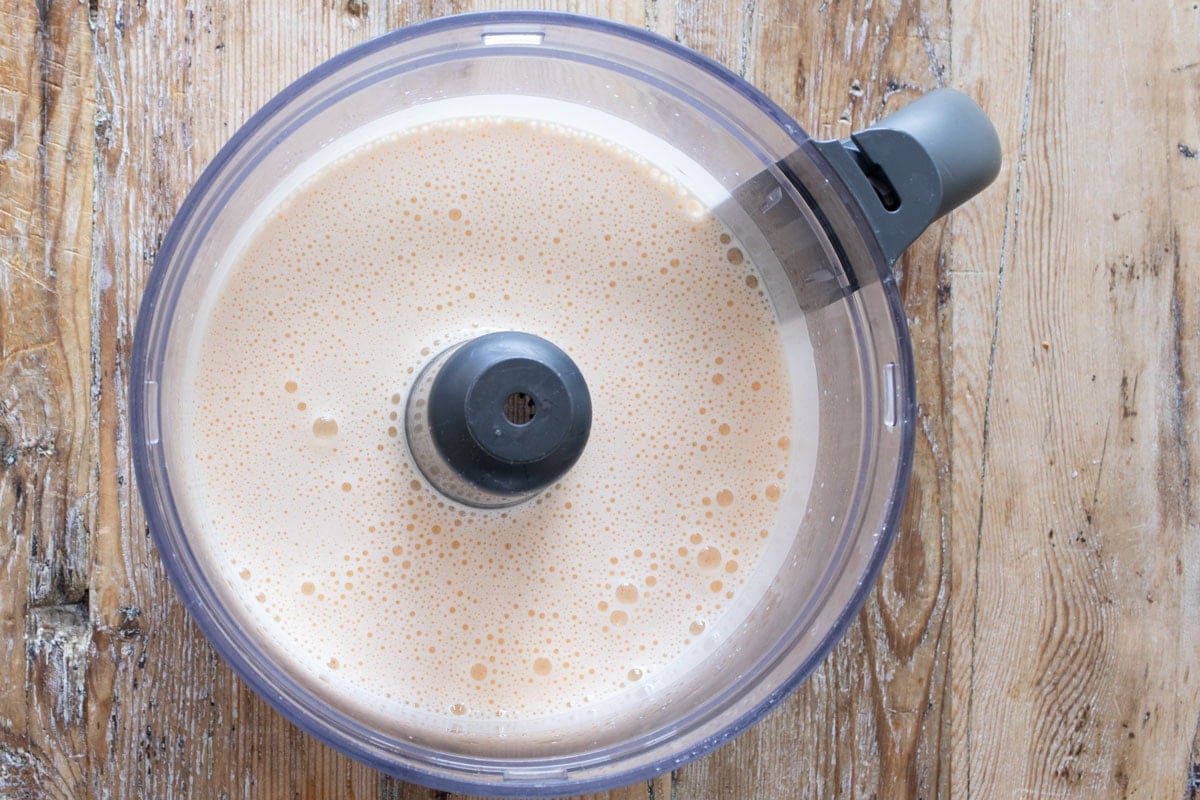 Whipped frothy eggs in a food processor bowl.
