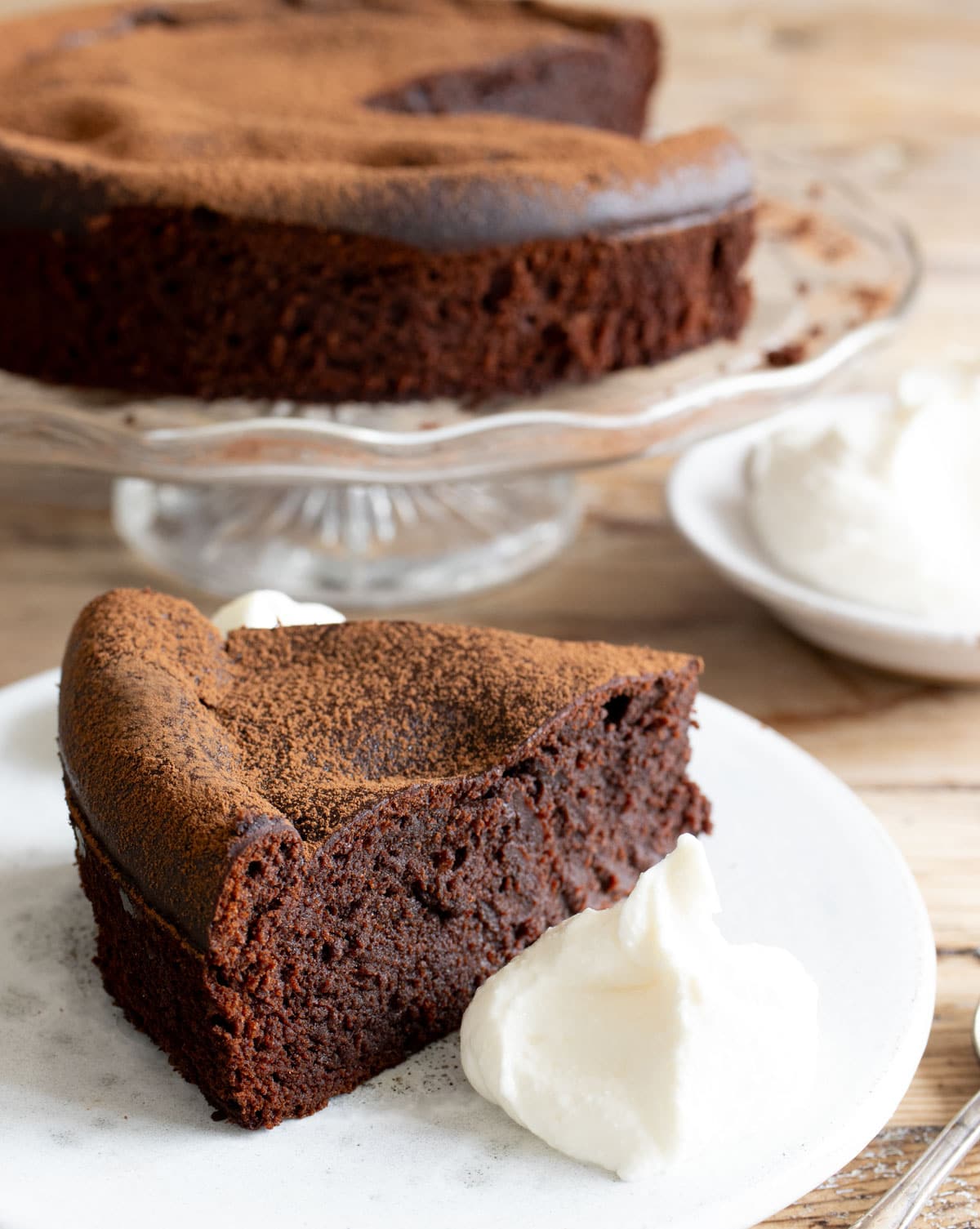 A slice of chocolate cake with whipped cottage cheese on the side.