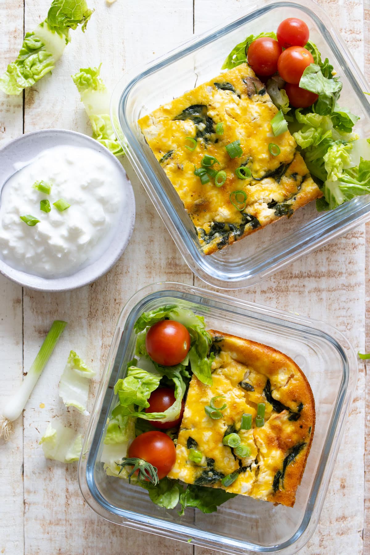 Meap prep portions of cottage cheese egg bake in single glass containers with a side salad.