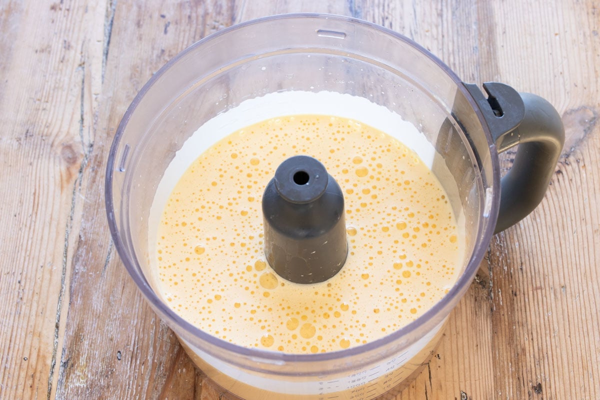 Whipped eggs in a food processor bowl.