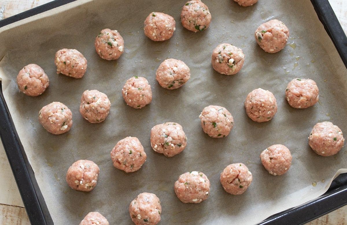 Raw meatballs on the baking tray.
