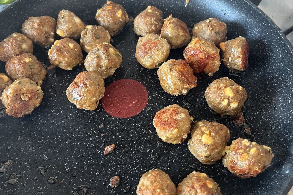 Lamb feta meatballs in a frying pan.