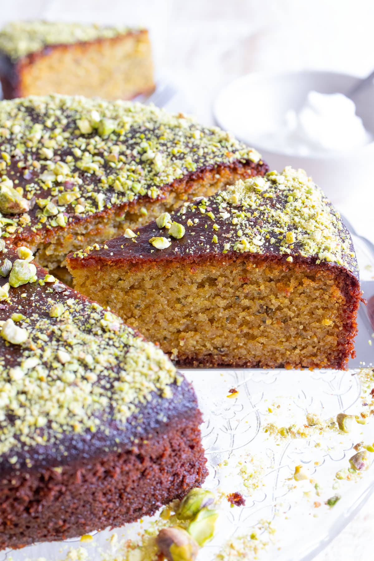 A keto pistachio cake with a slice of cake cut out.