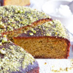 A slice of pistachio cake topped with pistachio crumbles.