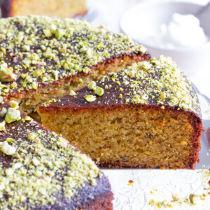 A slice of pistachio cake topped with pistachio crumbles.