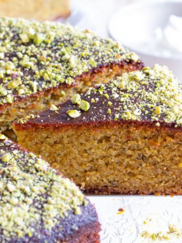 A slice of pistachio cake topped with pistachio crumbles.